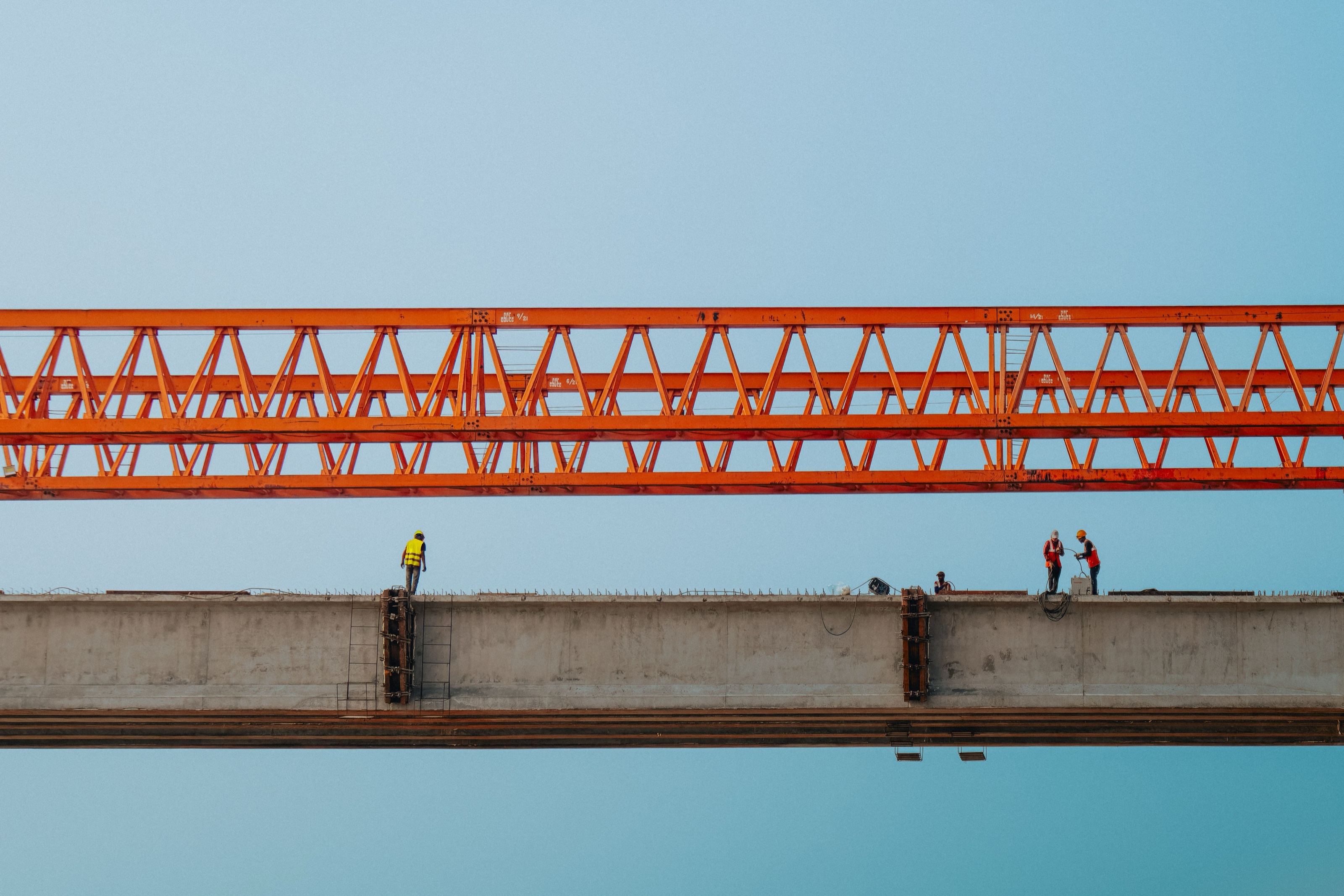 A wide industrial hall with an orange overhead crane