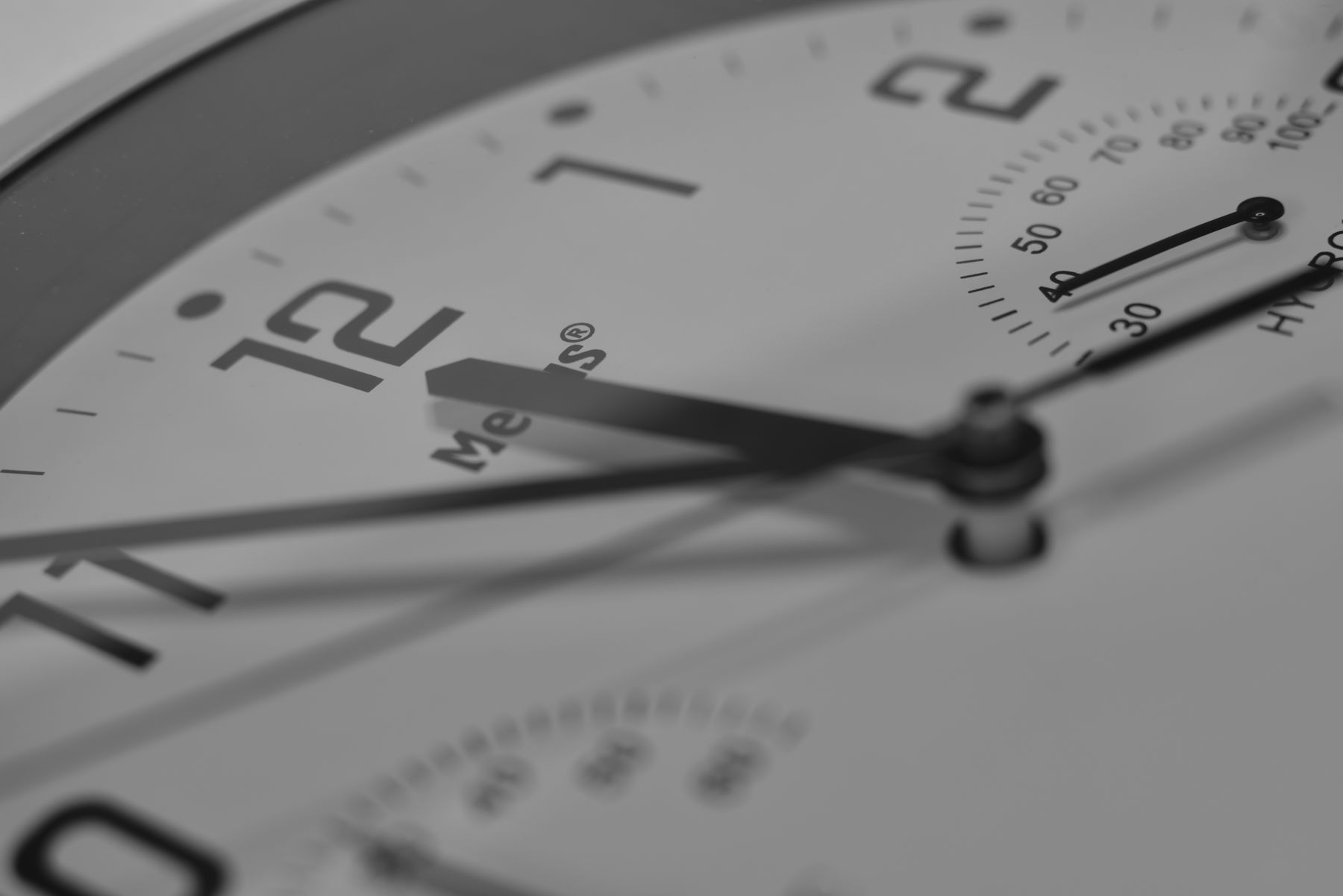 Close-up of a clock face, the hands sweeping past twelve